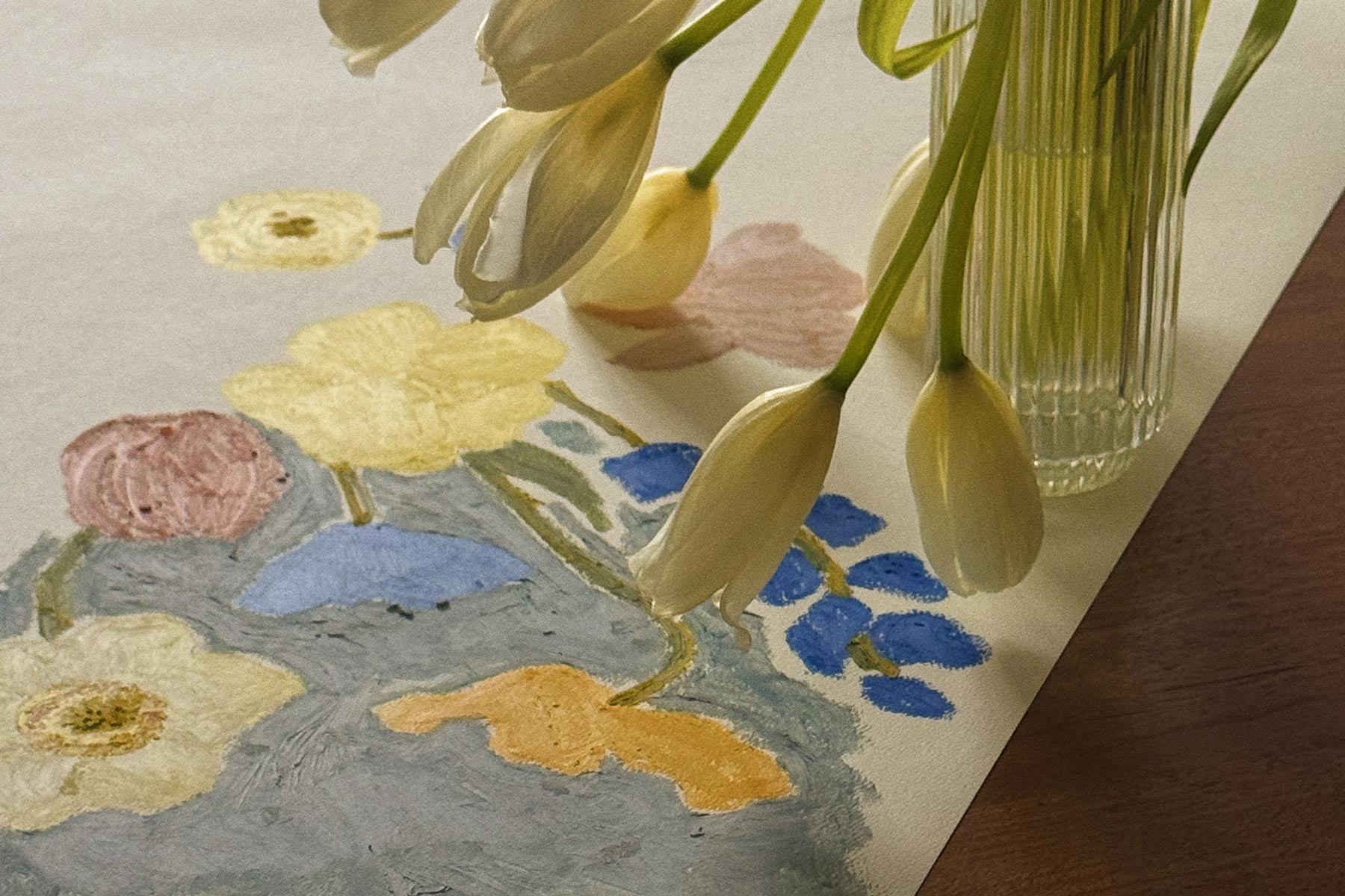 Clear glass vase with tulips sitting on top of a unfinished oil pastel painting.