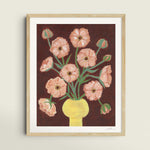 Framed artwork of a floral bouquet of pink butterfly ranunculus in a yellow vase and brown background. The artwork is hung up on a wall with window shadows.
